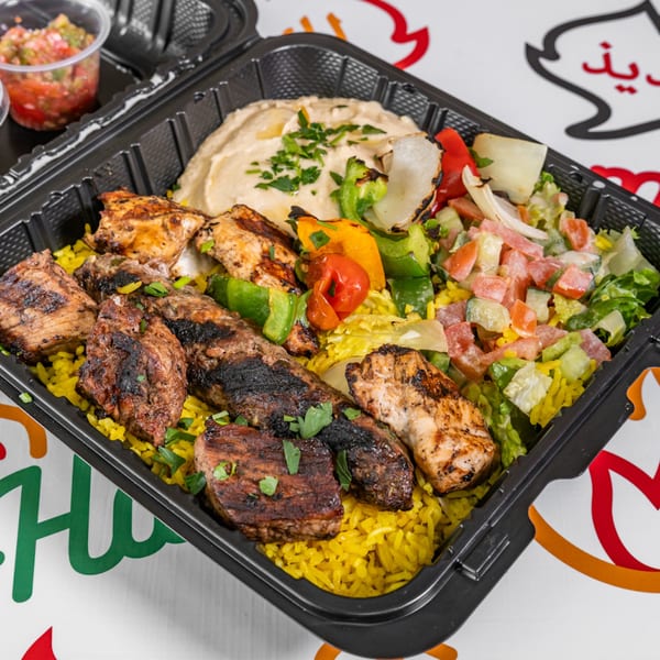 Yalla Shawarma's mixed grill platter with chicken, beef, rice, hummus, salad, and grilled vegetables.